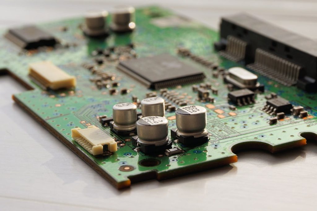 Detailed view of a green circuit board featuring capacitors and microchips.